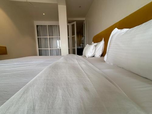a large bed with white pillows in a room at Baga Beach Sea Salacia in Goa