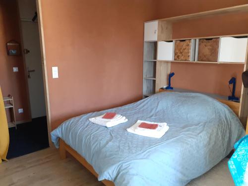 a bedroom with a bed with two towels on it at La Cigogne in Uffholtz