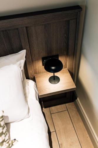a black stool sitting on a night stand next to a bed at The Nines in Bangor