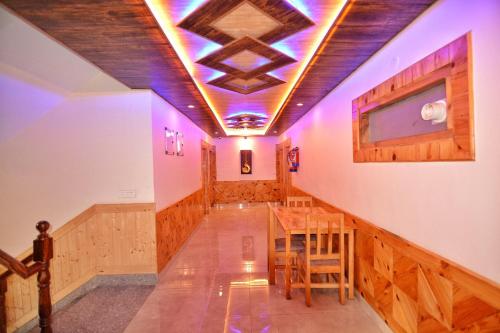 a room with a table and some purple lights at Dreamscape Manali in Manāli