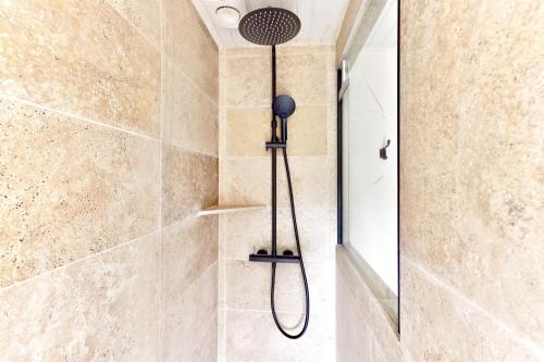 eine Dusche mit Duschkopf in einem Badezimmer in der Unterkunft Maison moderne, en pierre avec terrasse pour 6 in Montignac