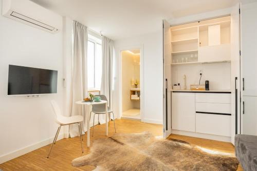 una cocina blanca con mesa y sillas en una habitación en Apartment Musala N 04, en Varna
