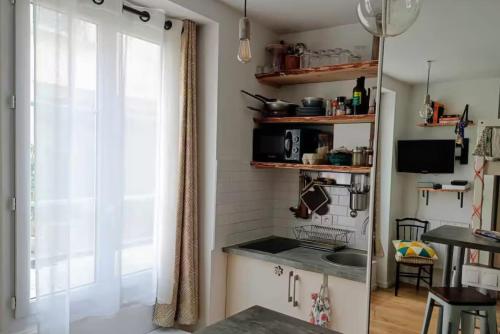 une cuisine avec un évier et une fenêtre dans l'établissement Corner of Paradise, à Paris