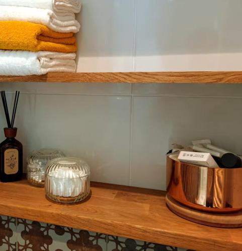 une étagère en bois avec une marmite et des serviettes. dans l'établissement Corner of Paradise, à Paris