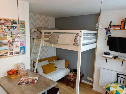 Cette petite chambre comprend des lits superposés et un bureau. dans l'établissement Corner of Paradise, à Paris