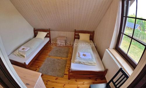 a small room with two beds and a window at Dzūkijos uoga in Viršurodukis