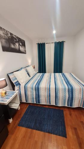 a bedroom with a bed and a table and a window at Maligueira Apartment in Leiria
