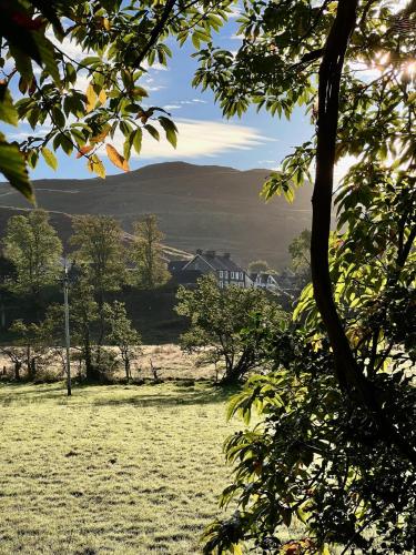 a field of grass with a house in the distance at 1 The Cairn Kilmartin - Beautiful Victorian Flat, Pet Friendly in Kilmartin