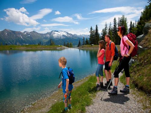 a group of people standing around a lake at Rainberghof***, Appartements in Rauris