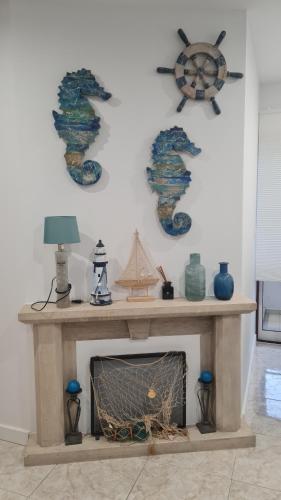 a living room with a fireplace with a painting on the wall at Maligueira Apartment in Leiria