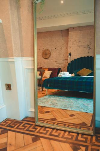 a mirror in a room with a bed and a couch at 89 The Merchants- Chic Aparthotel by The House of Danu in Edinburgh