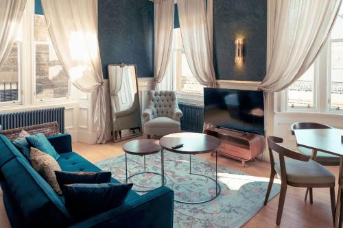 a living room with a couch and a tv at 89 The Merchants- Chic Aparthotel by The House of Danu in Edinburgh