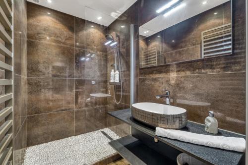 une salle de bain avec un lavabo et une douche dans l'établissement Ebène, à Annecy