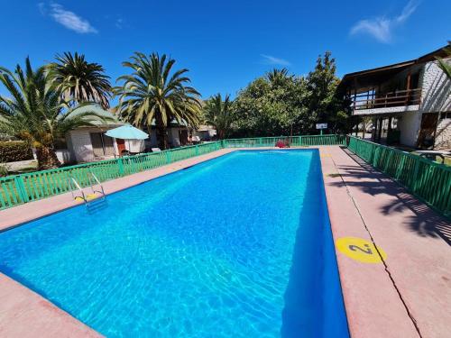 a large swimming pool with blue water at Cabañas Yunkai in Vicuña