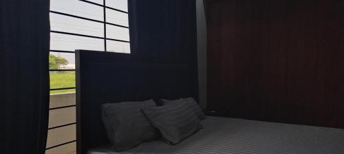 a bed with a pillow in a room with a window at 430 Islamabad in Islamabad