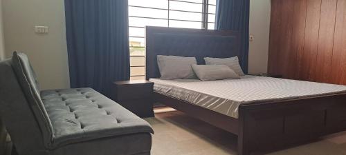 a bedroom with a bed and a chair and a window at 430 Islamabad in Islamabad