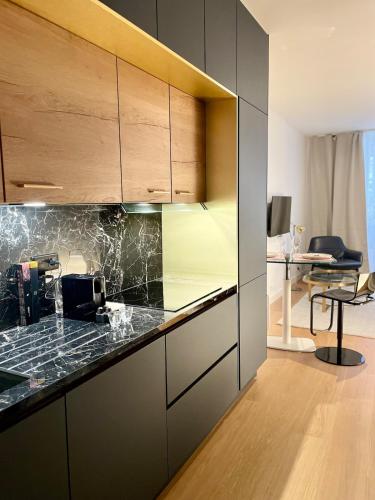 une cuisine avec des comptoirs noirs et des armoires en bois dans l'établissement Saint-Germain Prestige - Luxury Parisian Hideaway, à Paris