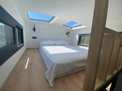 ein Schlafzimmer mit einem Bett und zwei Dachfenstern in der Unterkunft Boaz Tiny House in Izmir