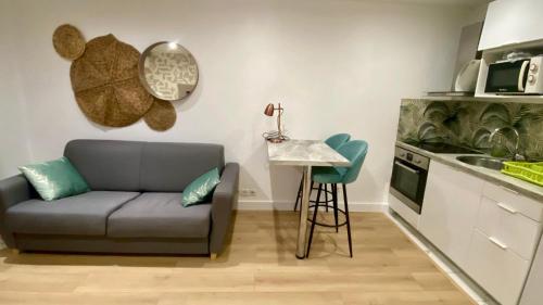 un salon avec un canapé et une table dans une cuisine dans l'établissement Studio Bricka - 200m to the beach, parking, clim, terrace, à Antibes