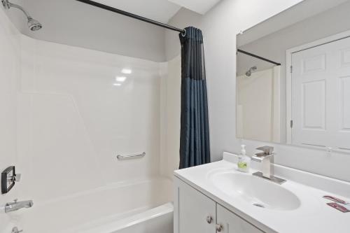 a white bathroom with a sink and a mirror at Willow Inn Suites in Eau Claire