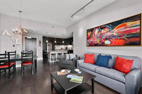 a living room with a couch and a table at 2BR Condo with Balcony, Free Tix, Walk to Downtown in Asheville