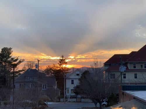 a sunset in a city with houses and trees at 2BR Condo with Balcony, Free Tix, Walk to Downtown in Asheville
