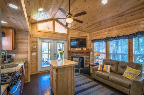 a living room with a couch and a ceiling fan at Lakeview 2BR Tiny Home near Trails and Bocce in Flat Rock