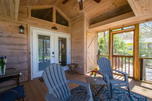 two chairs and a table in a cabin with a porch at Lakeview 2BR Tiny Home near Trails and Bocce in Flat Rock