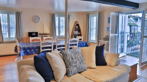 a living room with a couch and a dining room at Harbourside Apartment in Mevagissey