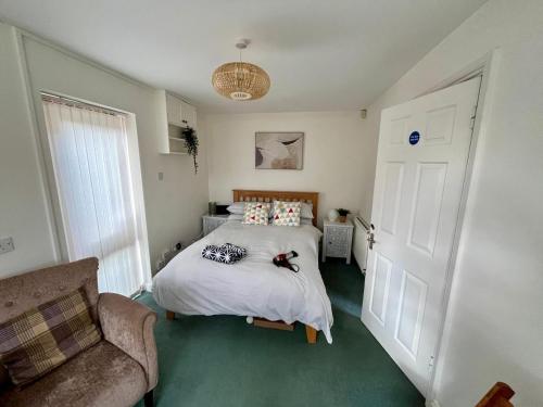 a bedroom with a bed and a couch at Spacious Village House near Oxford with Woodburner in Horspath