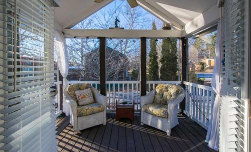 a screened in porch with two chairs and a table at Gorgeous 1BR Tiny Home with Pool and Bocce in Flat Rock