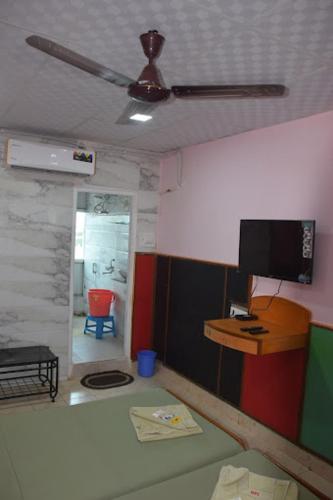 a living room with a ceiling fan and a tv at hotel prashant international in Gandhidham