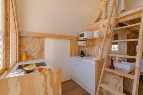 a small kitchen with a staircase in a tiny house at Costa del Sol Glamping Village in Fuengirola