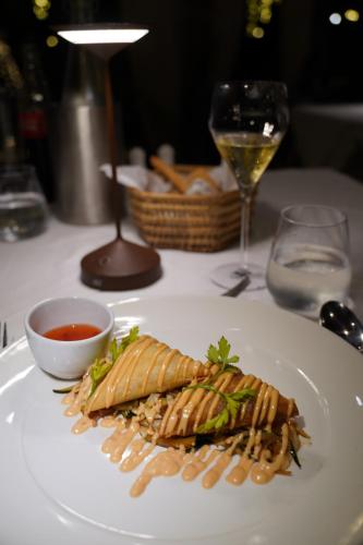 a plate of food on a table with a glass of wine at Alma Boutique Hotel in Jambiani