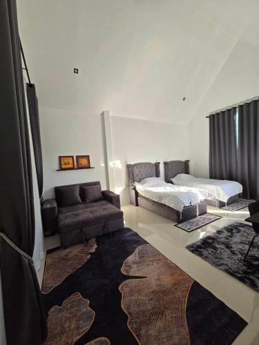 a living room with a bed and a couch at เลอร์กบินทร์ in Kabin Buri
