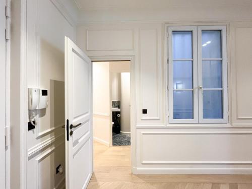 un couloir avec une porte et une fenêtre dans l'établissement Urban Flat 191 - Luxury 3 Bedroom Apartment - Madeleine, à Paris