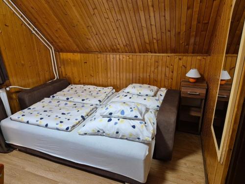 sypialnia z łóżkiem w drewnianym pokoju w obiekcie Crystal Sóstó Apartman w Nyíregyházie