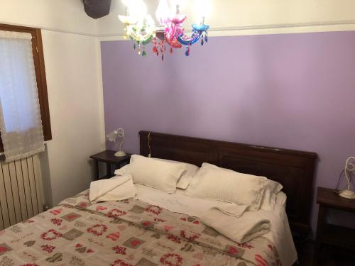 a bedroom with a bed and a chandelier at Agriturismo Villa Greggio in Casalserugo