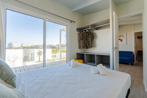 a bedroom with a large white bed and a large window at Costa del Sol Glamping Village in Fuengirola