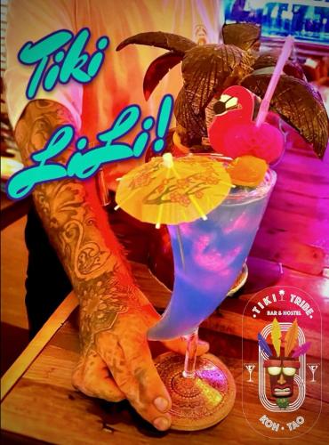 a hand holding a drink with a bird on it at Tiki Tribe Bar & Hostel in Koh Tao