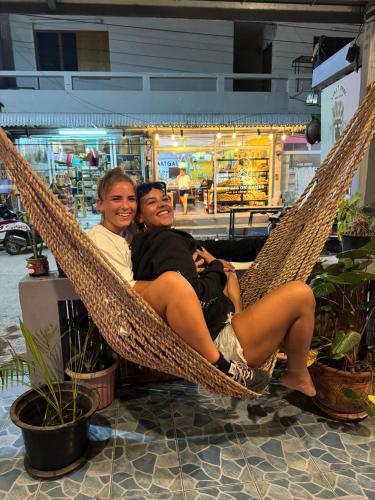 two people sitting in a hammock in a store at Tiki Tribe Bar & Hostel in Koh Tao