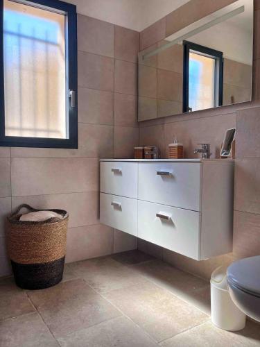 une salle de bain avec un lavabo et un miroir dans l'établissement Villa Filogiu, dans un petit lotissement calme, à Calenzana