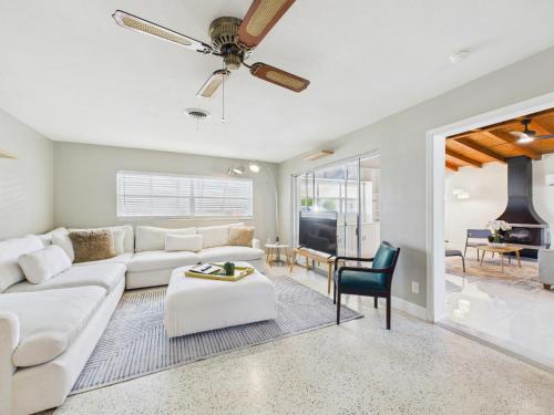 a living room with a white couch and a ceiling fan at Pet-Friendly 3BR Coastal Retreat Walk to Beach in Satellite Beach