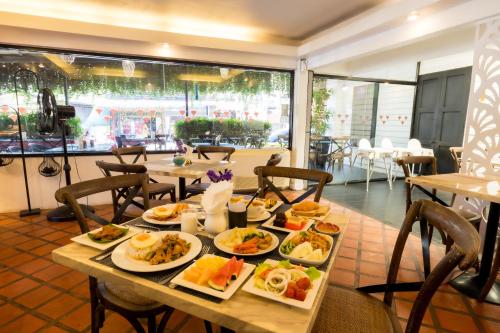 a table with plates of food on it in a restaurant at Nak Nakara Hotel in Chiang Rai
