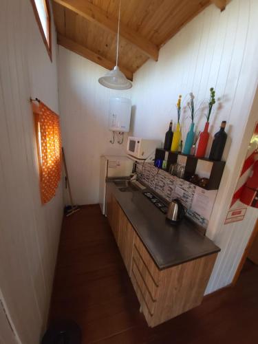 a kitchen with a counter with vases on the wall at D'Charrúas Cabañas Chajarí in Chajarí