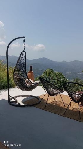 a couple of chairs sitting on a patio with a view at Miterio Mundo Nuevo in Minca