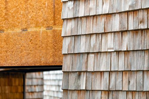 a close up of a wooden building with a building at Design-Chalet mit Teilseeblick, Pool, Spa & Restaurant in Lochau