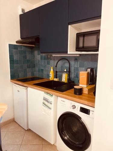 a kitchen with a washing machine and a sink at Heure Normande Charmant T2 au pieds de la gare in Rouen