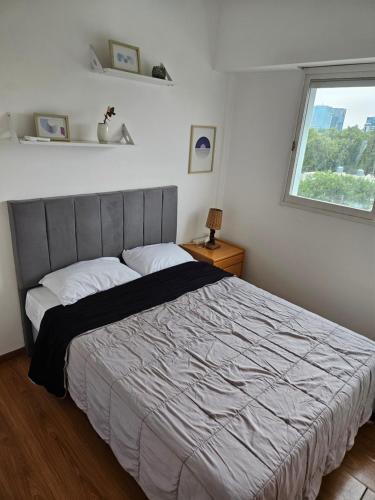 ブエノスアイレスにあるApartamento frente al Parque Sarmientoの大きなベッドと窓のある寝室