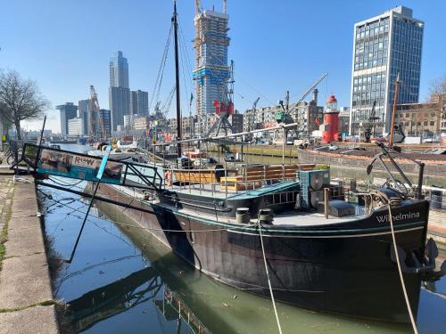 a boat docked in the water in a city at Rooms on Water in Rotterdam